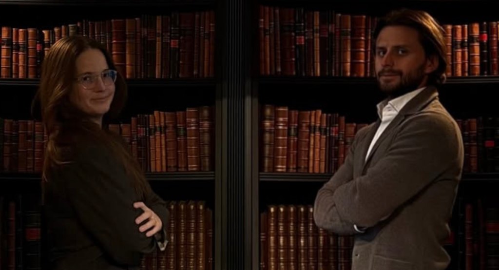 Melania Bogiel and Kamil Safulak in the bookshop, in front of bookcases with leather spines