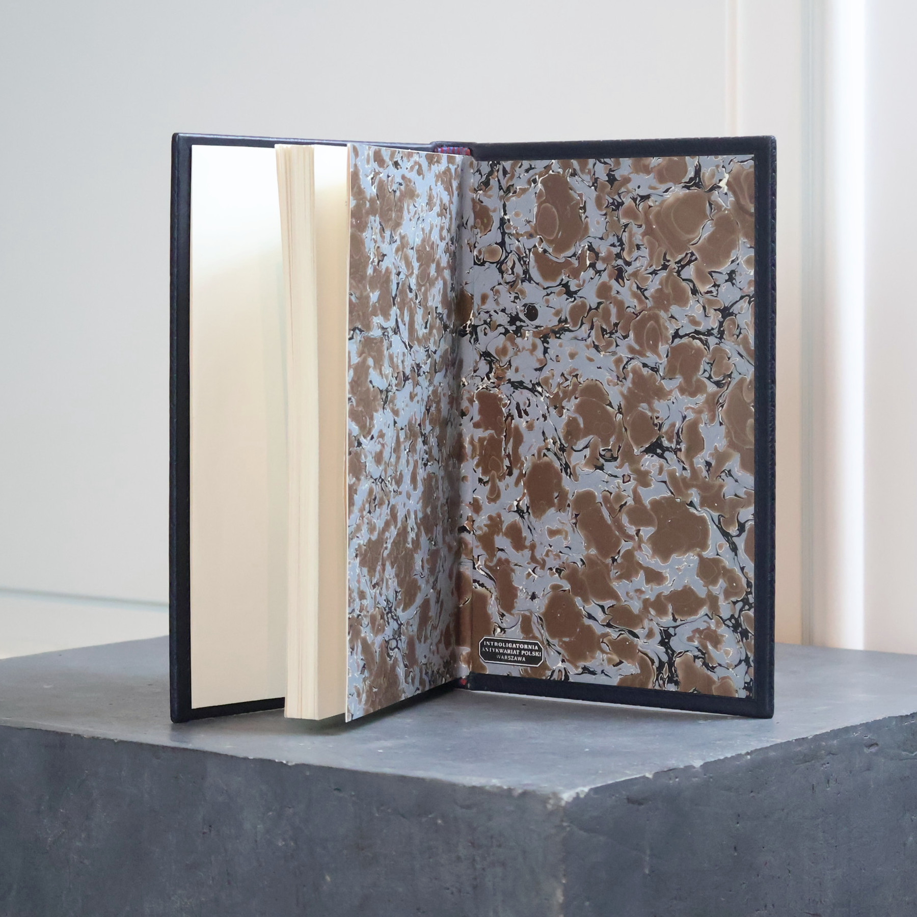 Marbled endpapers in shades of brown and blue, with a bookbinder's label reading "Achilleis"